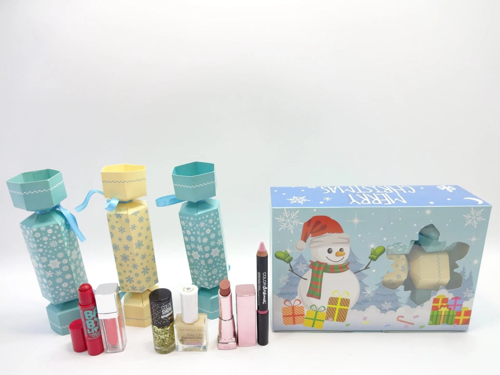 Festive Maybelline cracker set including lip and nail products beside snowman Christmas box
