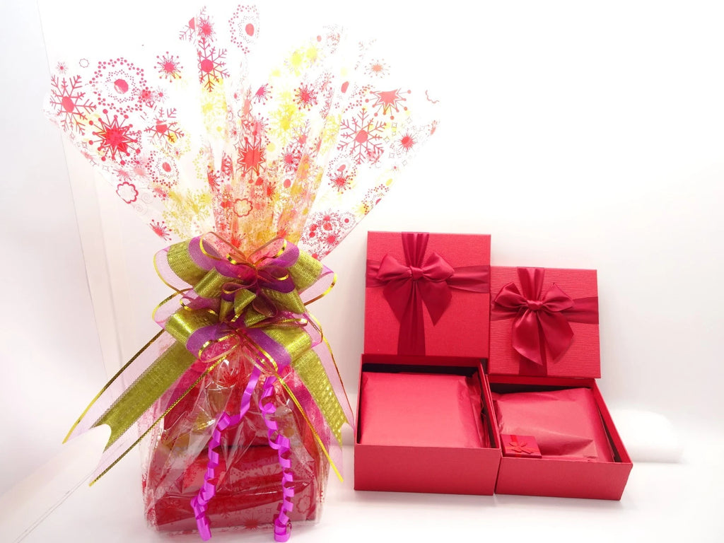 Red gift boxes with ribbons and a colorful bouquet on a white background