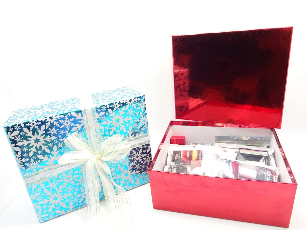 Open red box with Maybelline makeup products neatly arranged inside the beauty gift set