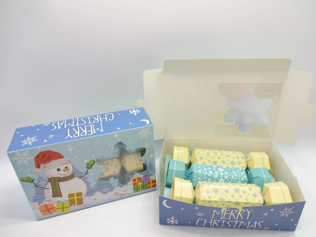 Open Maybelline Christmas cracker box showing pastel yellow and blue beauty crackers inside