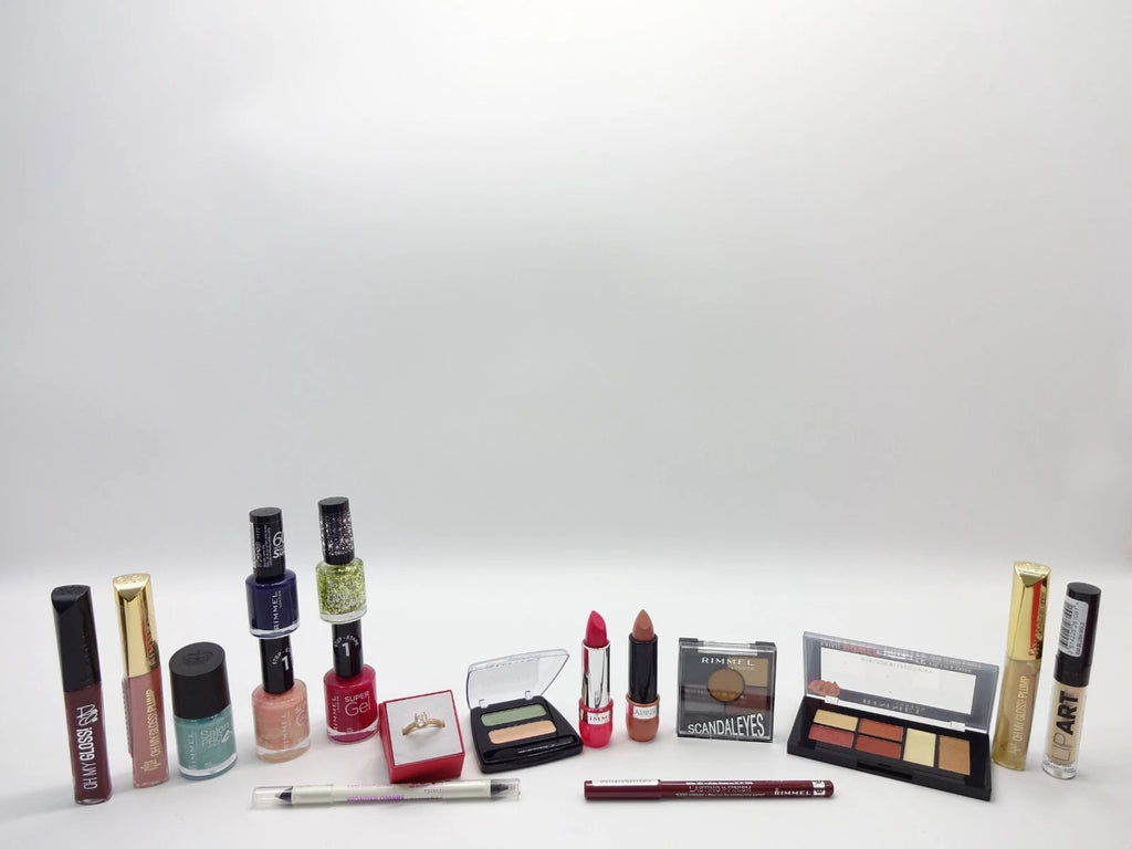 Collection of makeup products including lipsticks, nail polishes, and a palette on a white background