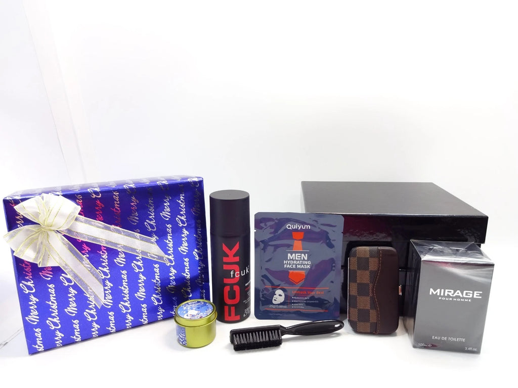 Close-up of men’s luxury grooming gift set showing FCUK deodorant, Mirage perfume, hydrating face mask, grooming tools, and candle beside gift box.