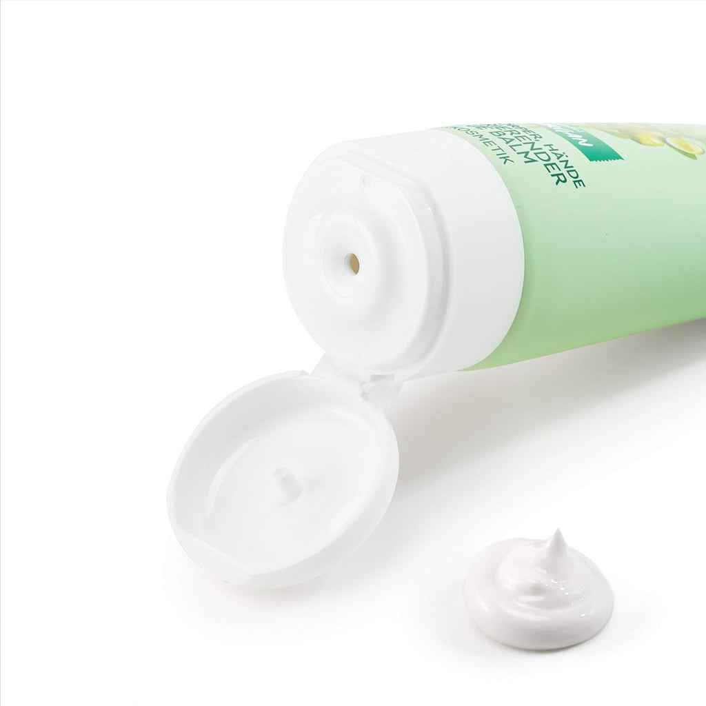 Green tube of cream with white cap on a white background