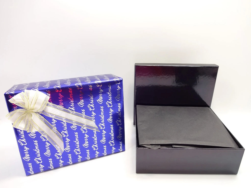 Side-by-side view of blue Merry Christmas wrapped box with gold bow and black presentation box for men’s luxury gift set.