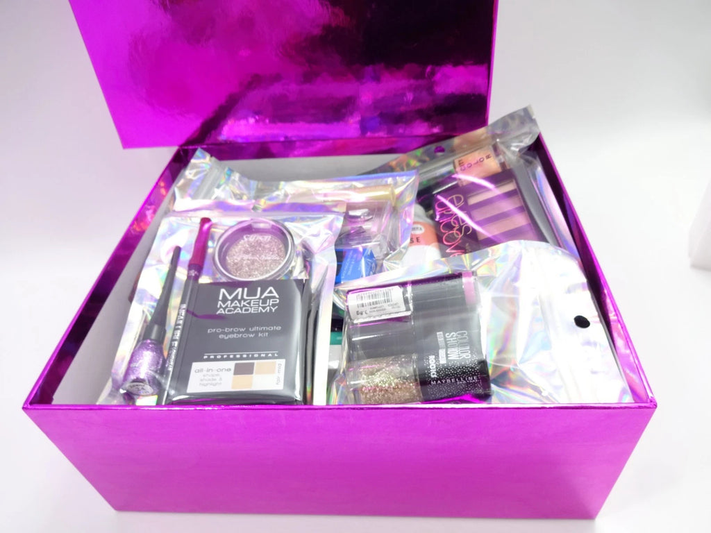 Close-up of pink luxury box filled with assorted beauty and fragrance items