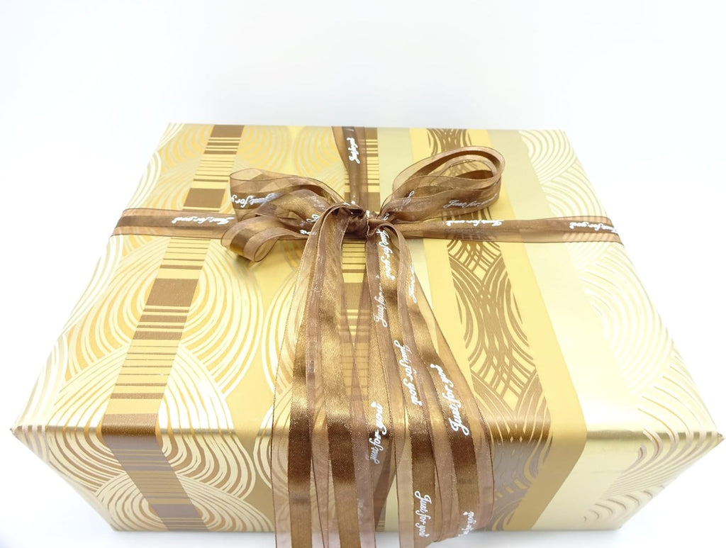 Flatlay of gold Father's Day gift box with matching brown ribbon and elegant wrapping