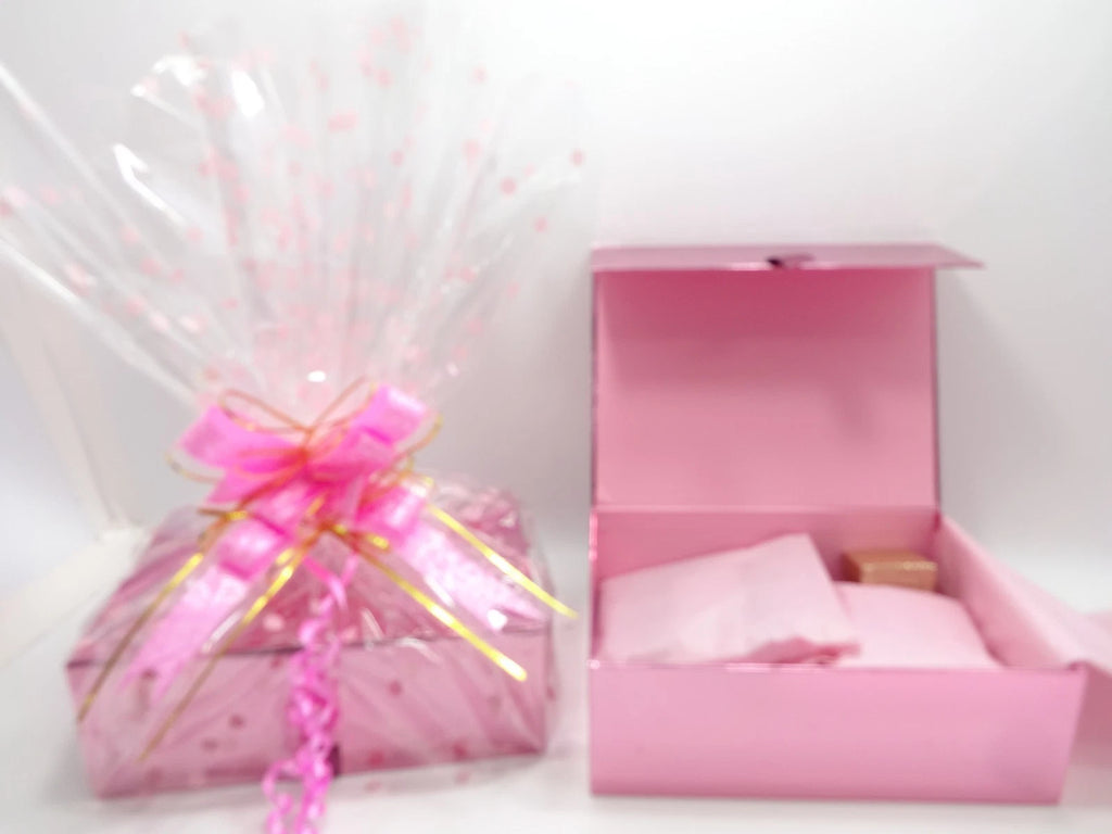 Pink luxury makeup gift box with lid open showing tissue wrapped Maybelline products inside