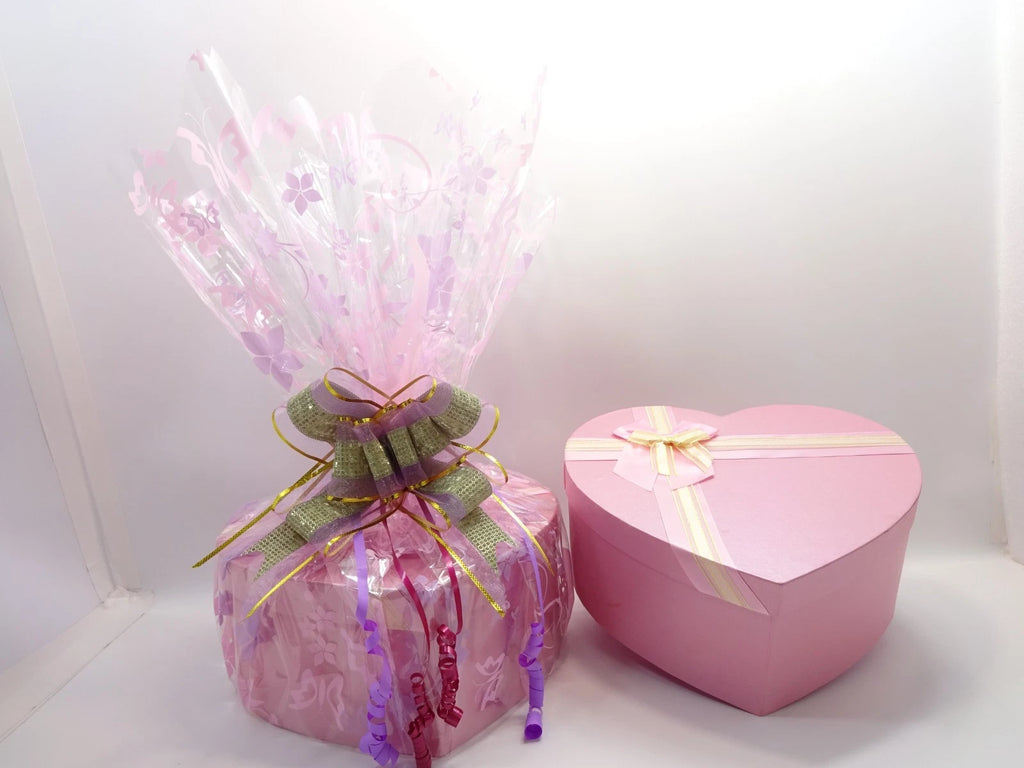 Open view of pink heart box showing neatly tissue-wrapped beauty products inside