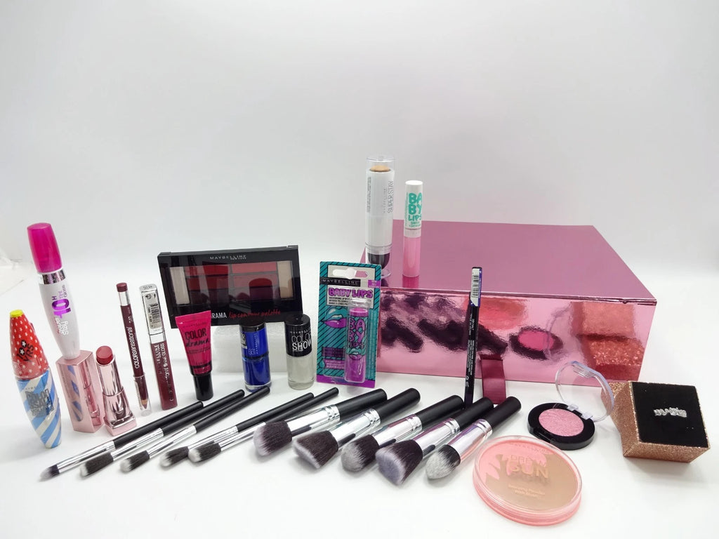 Collection of makeup products including brushes, compact powders, and a pink box on a white background