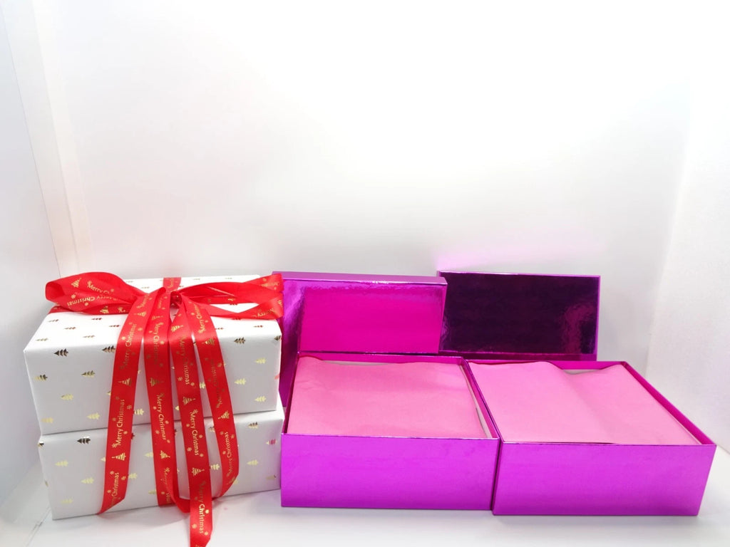 Luxury No7 Christmas collection arranged inside pink boxes with gold MAC makeup bag visible inside.