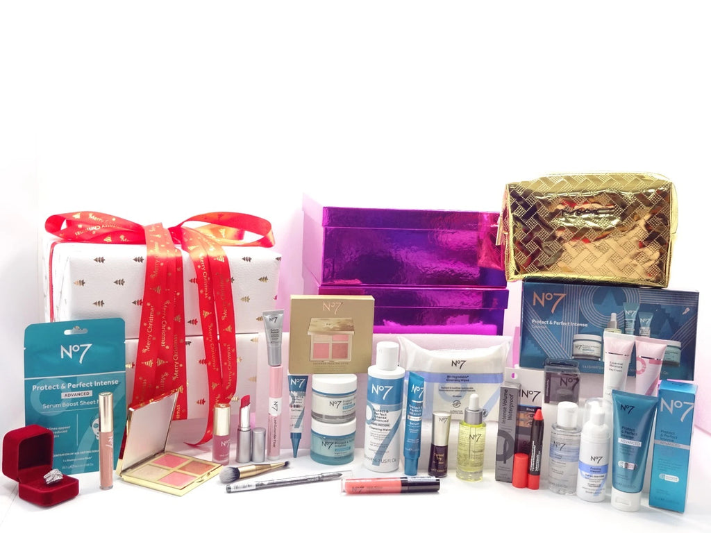 Complete display of No7 blockbuster gift set featuring skincare, cosmetics, and makeup tools beside wrapped gift boxes.