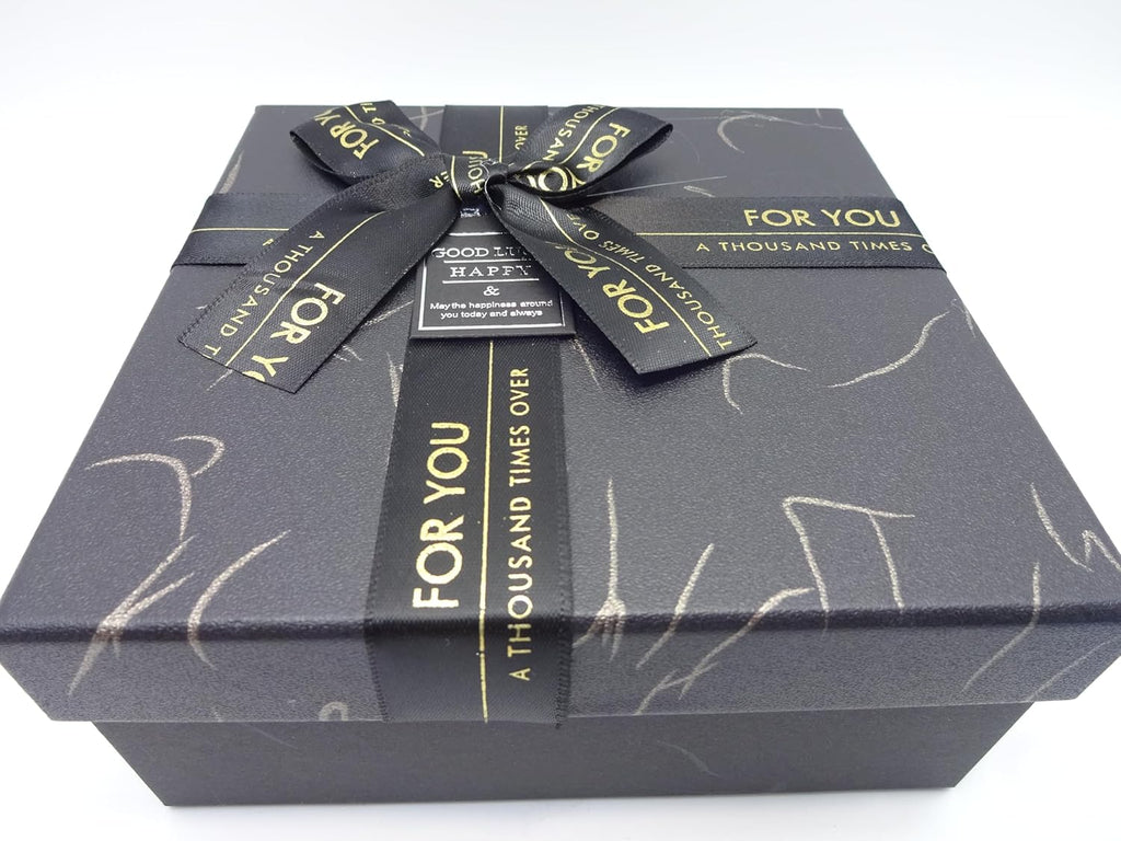 Close-up of the black gift box with a decorative gold bow, elegant presentation for special occasions.