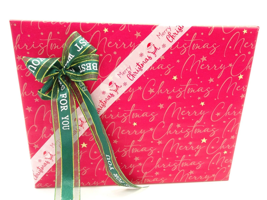 Front view of L’Oreal Merry Christmas gift box with festive ribbons and writing