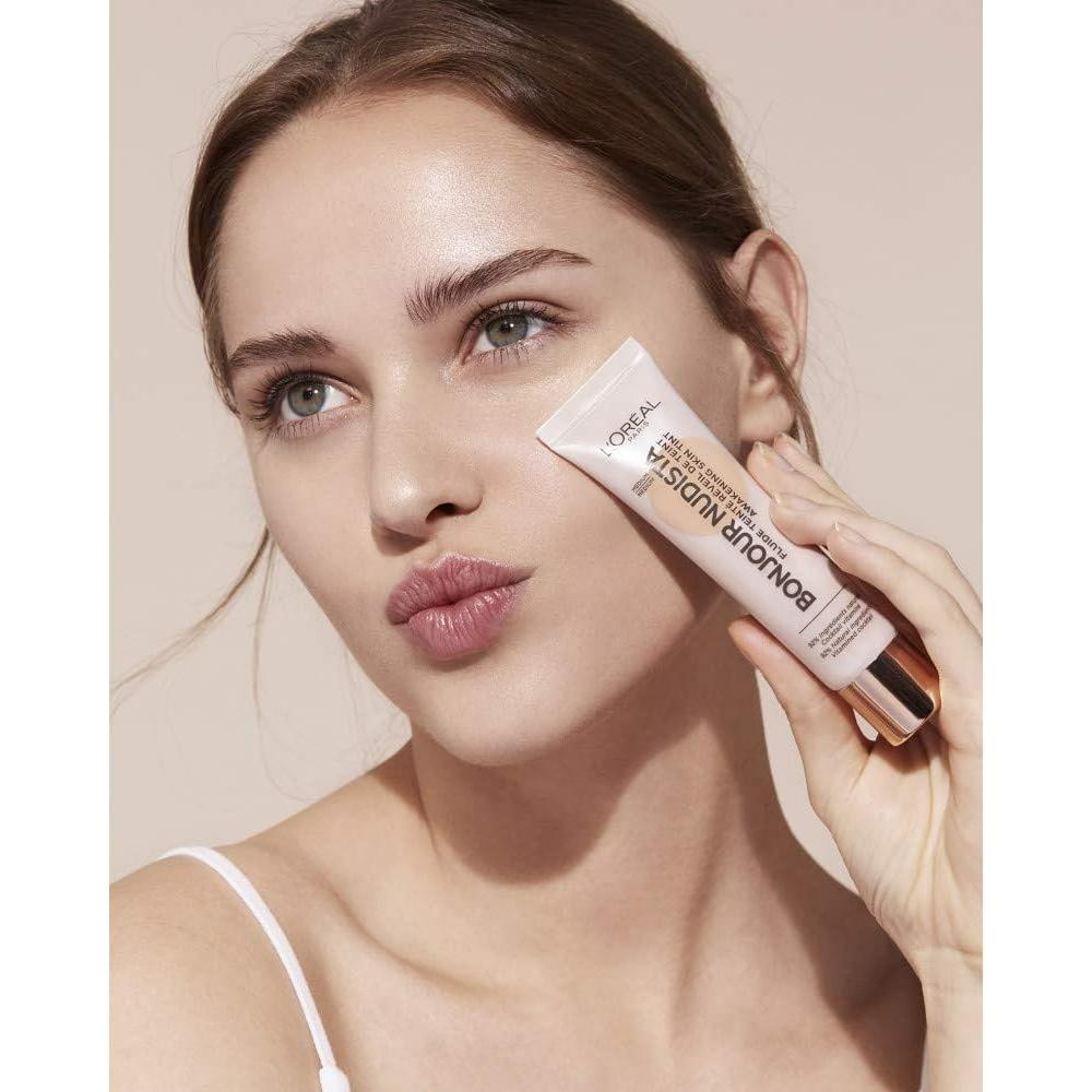 Model applying L'Oreal Paris Bonjour Nudista Skin Tint BB Cream showcasing a glowing, natural complexion.