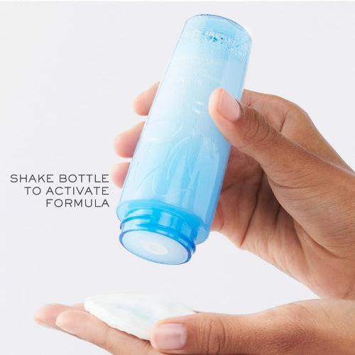 Lancôme Bi-Facil Eye Makeup Remover shown being poured onto a cotton pad during application
