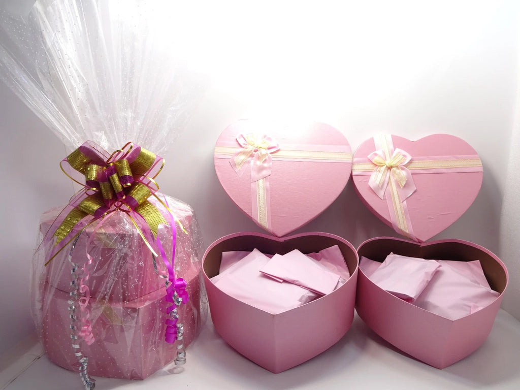Two-tier pink heart boxes, one wrapped in cellophane and the other open showing inner wrapping