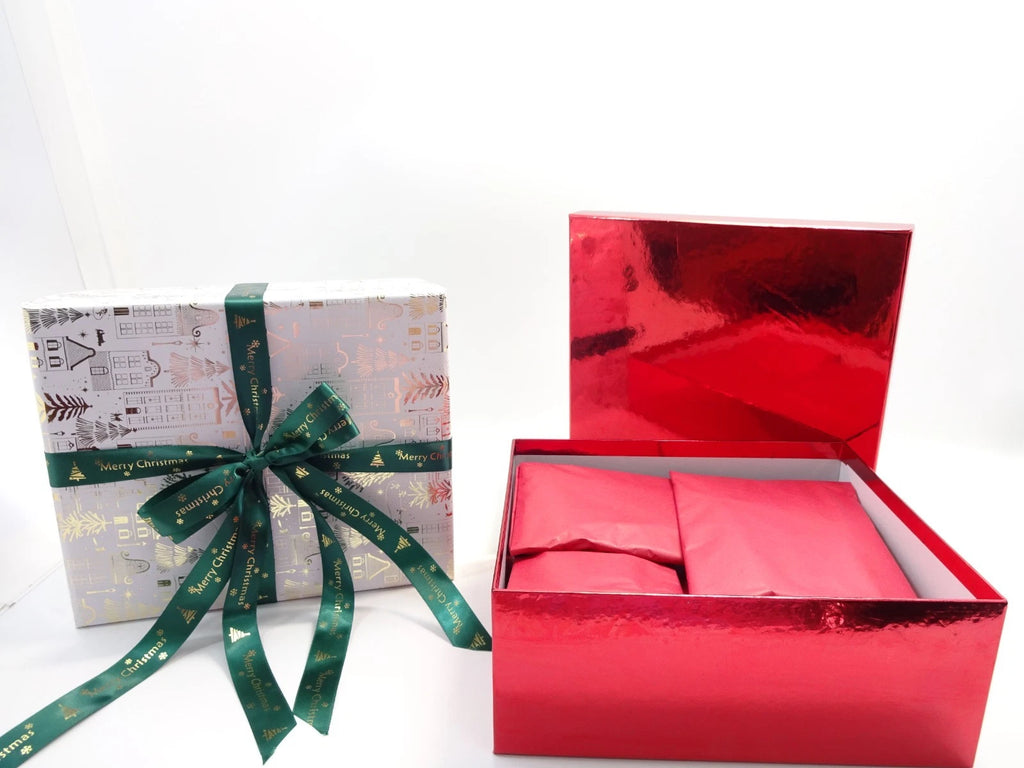 Opened red gift box showing holographic sealed beauty products, makeup brushes, and premium cosmetics