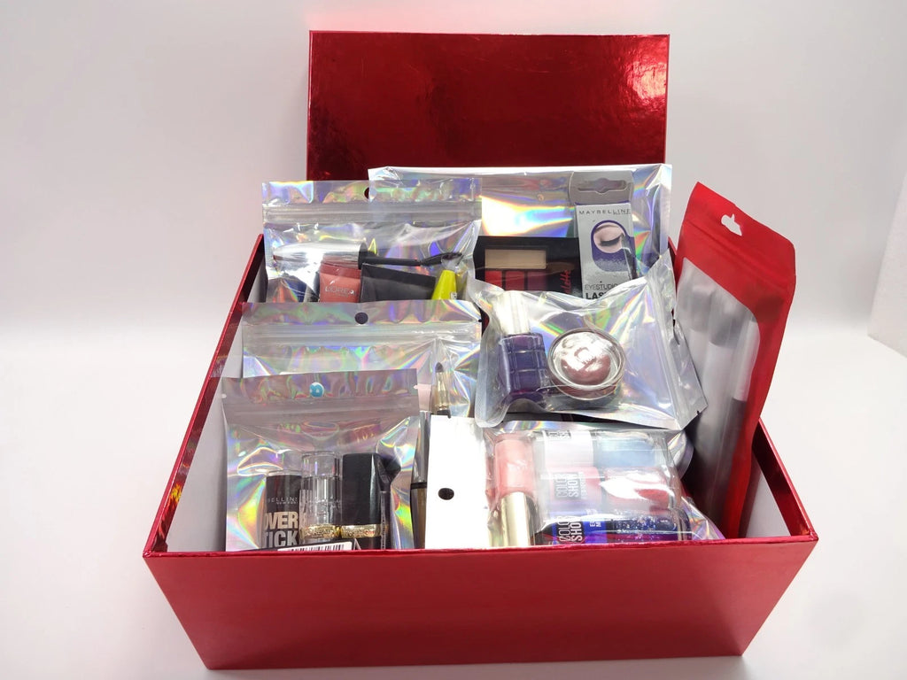 Open red metallic beauty box filled with L'Oréal and Maybelline products neatly packed in holographic pouches