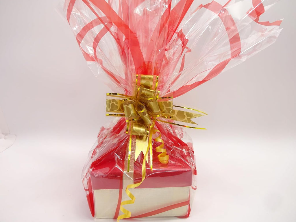 Detailed view of the gift wrapping with red cellophane, gold bow, and ribbon, enhancing the festive look.