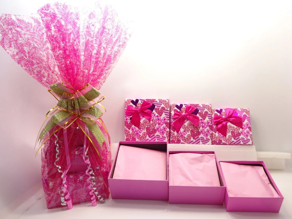 Open pink boxes lined with soft pink tissue paper holding sealed beauty items