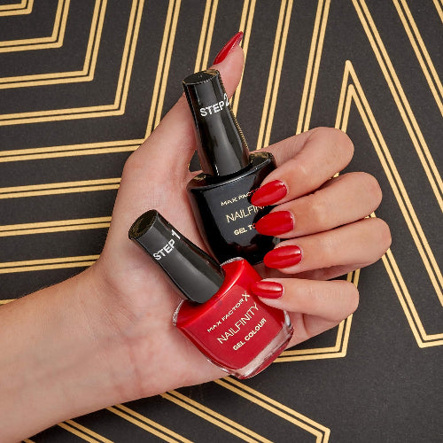 Model hand holding Max Factor Nailfinity Leading Lady 230 and Gel Top Coat with glossy red gel nails