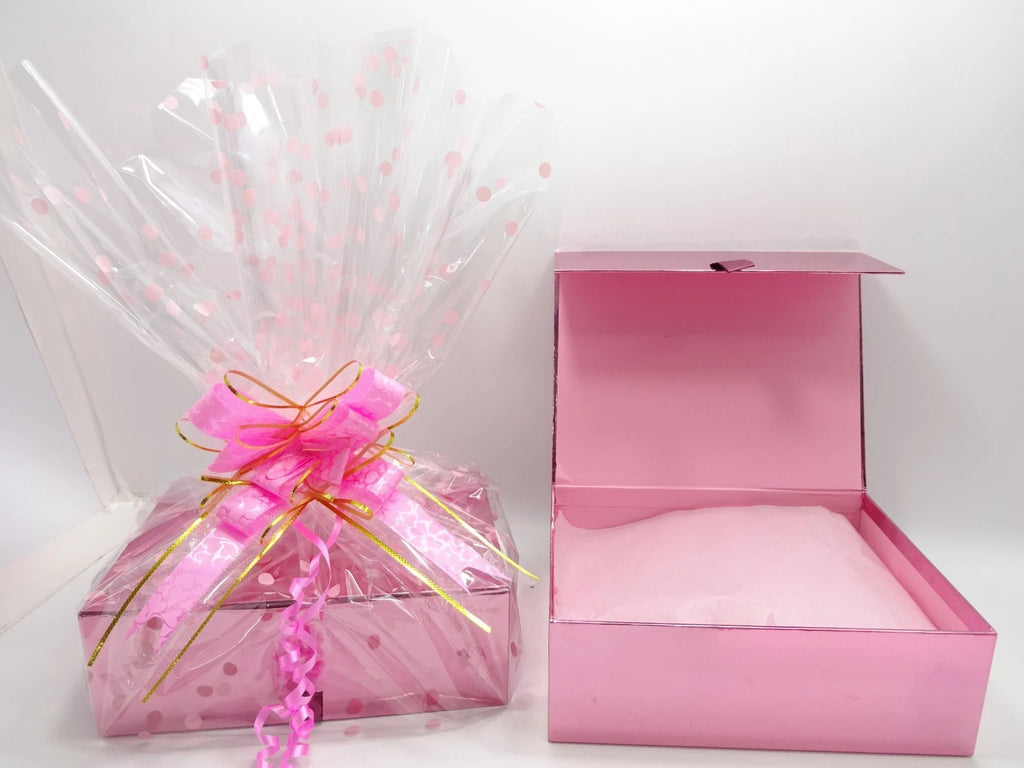 Pink luxury makeup gift box with lid open showing tissue wrapped Maybelline products inside