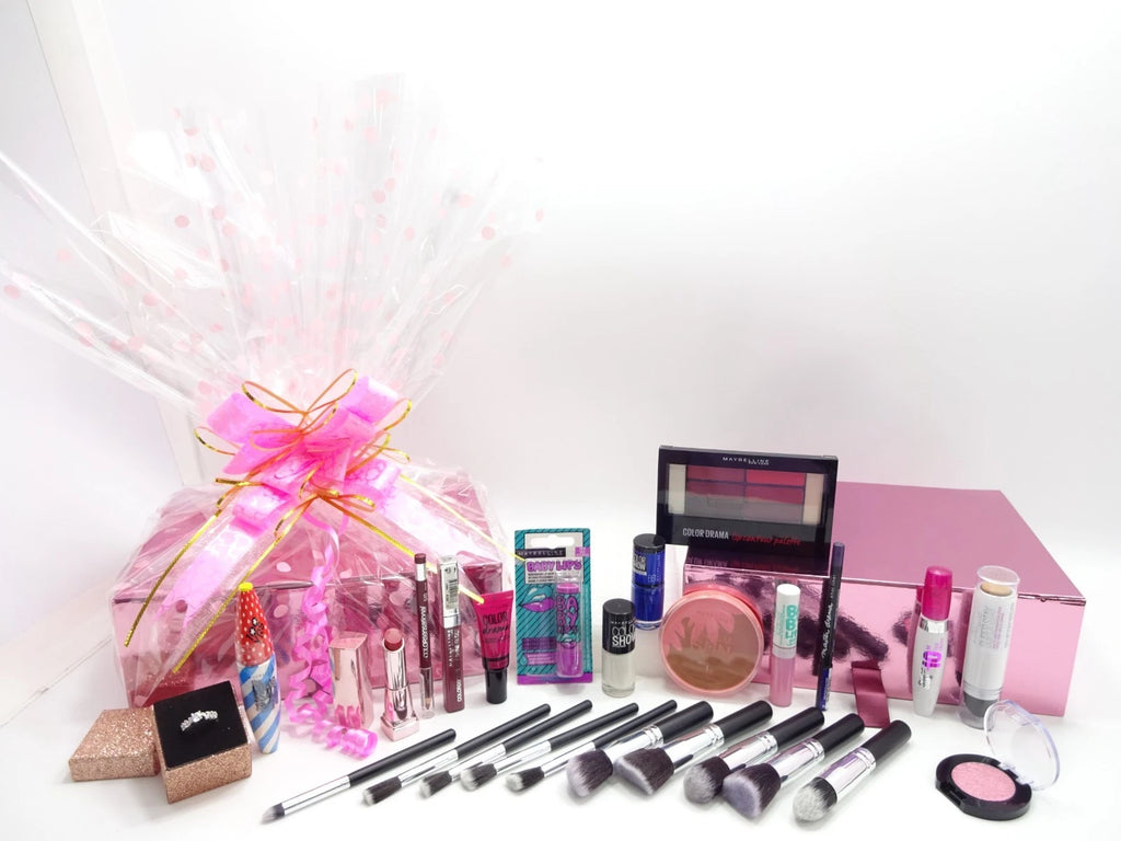 Maybelline 15 piece makeup gift set displayed outside pink gift box with brushes, lipsticks, mascara, and bronzer