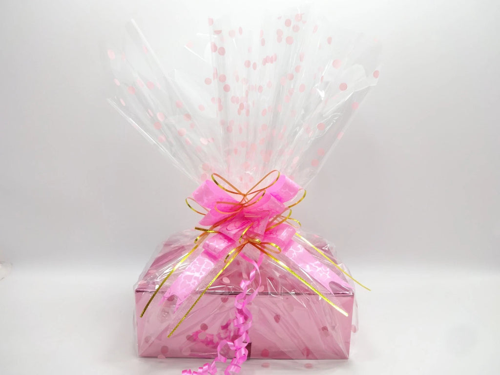 Pink Maybelline gift hamper wrapped with gold-trimmed bow and decorative polka dot wrap