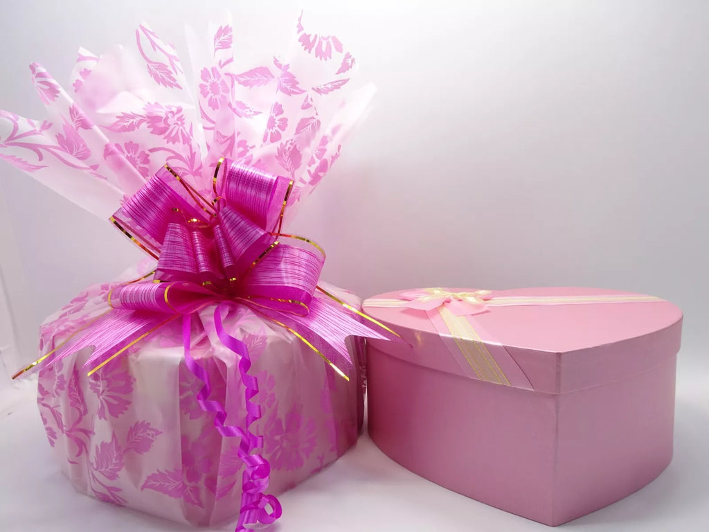 Pink heart-shaped gift box for the No7 skincare and makeup set, wrapped in a pink floral design and tied with a bow.