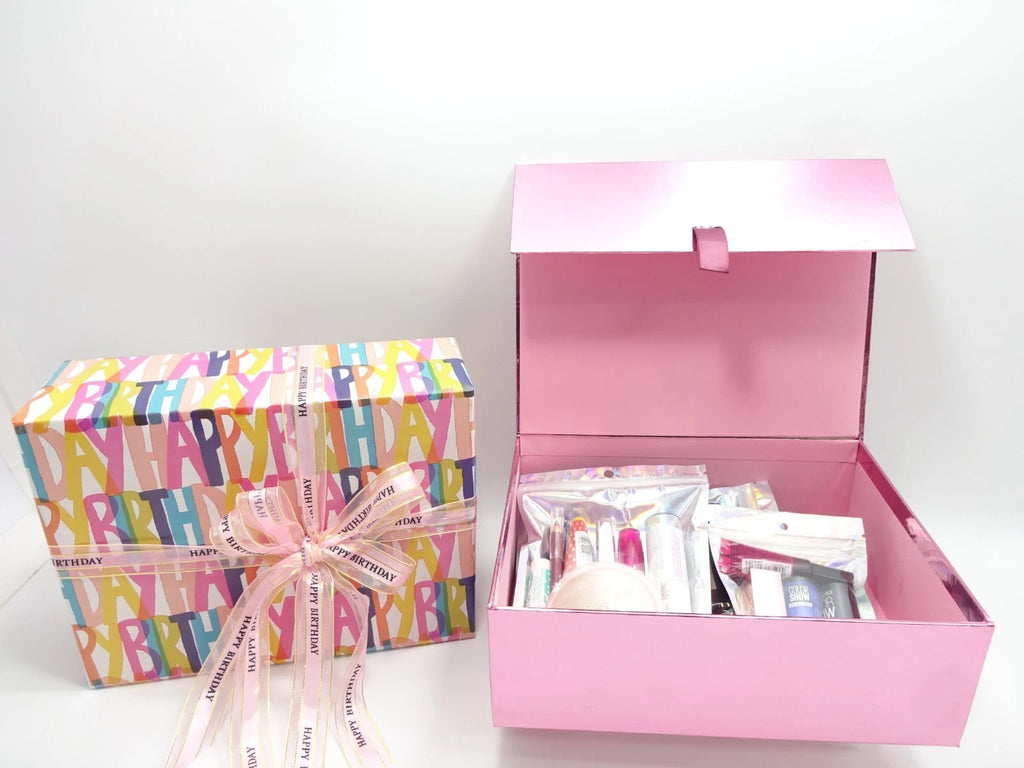 Open pink birthday gift box showing Maybelline makeup kit and beauty products inside