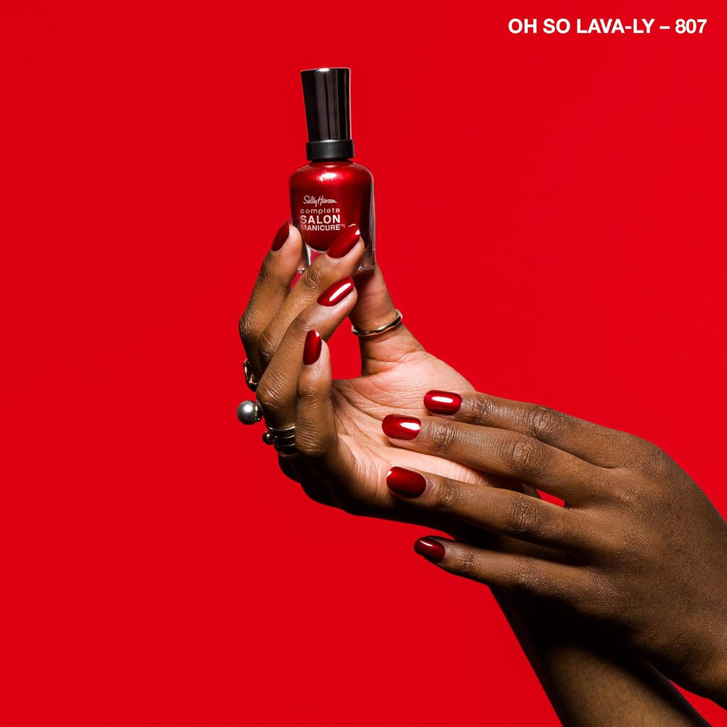 Hand swatch of Sally Hansen Complete Salon Manicure nail polish 807 Oh So Lava-Ly against red backdrop