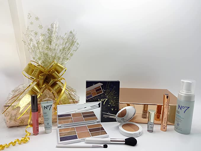 Boots No7 Limited Edition makeup and skincare collection, featuring a gold palette and other beauty essentials, alongside a gold-wrapped gift hamper.