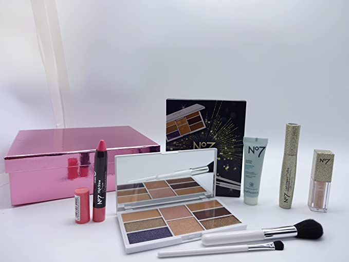 No7 shimmer makeup items displayed in front of the pink gift box, featuring eyeshadow palette, lip crayon, and more.